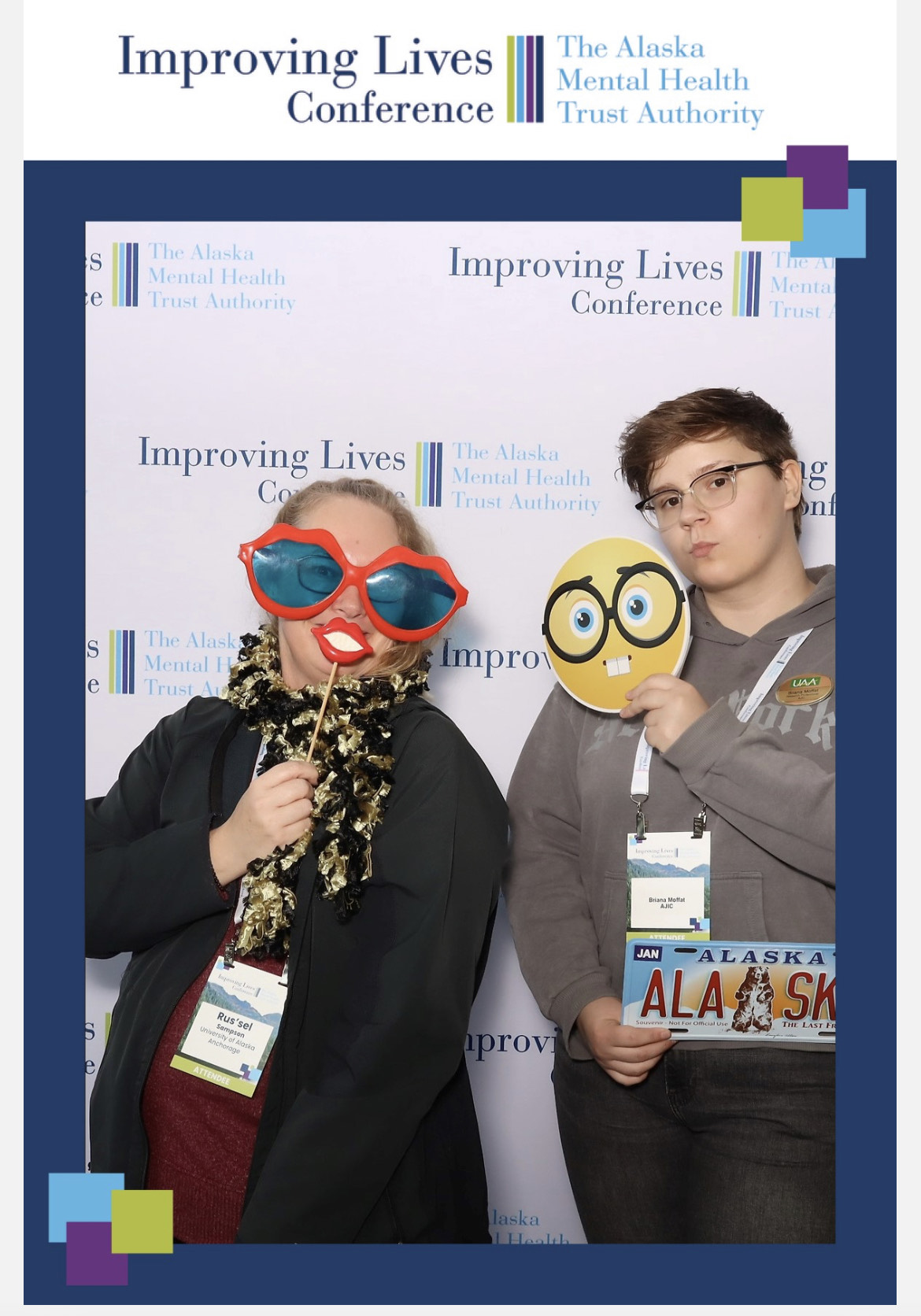 AJiC employees Rus'sel Sampson and Bri Moffat pose for a funny picture at the AMHTA Improving Lives Conference in front of a branded backdrop. Rus'sel Sampson wears oversize sunglasses, a tinsel scarf, and a fake lip mask. Bri is holding an Alaska license plate in one hand and an paper emoji in the other. 