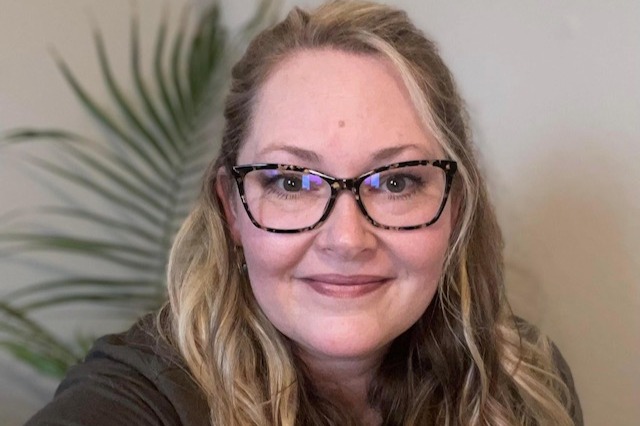 Rus'sel Sampson wears glasses and smiles at the camera. 