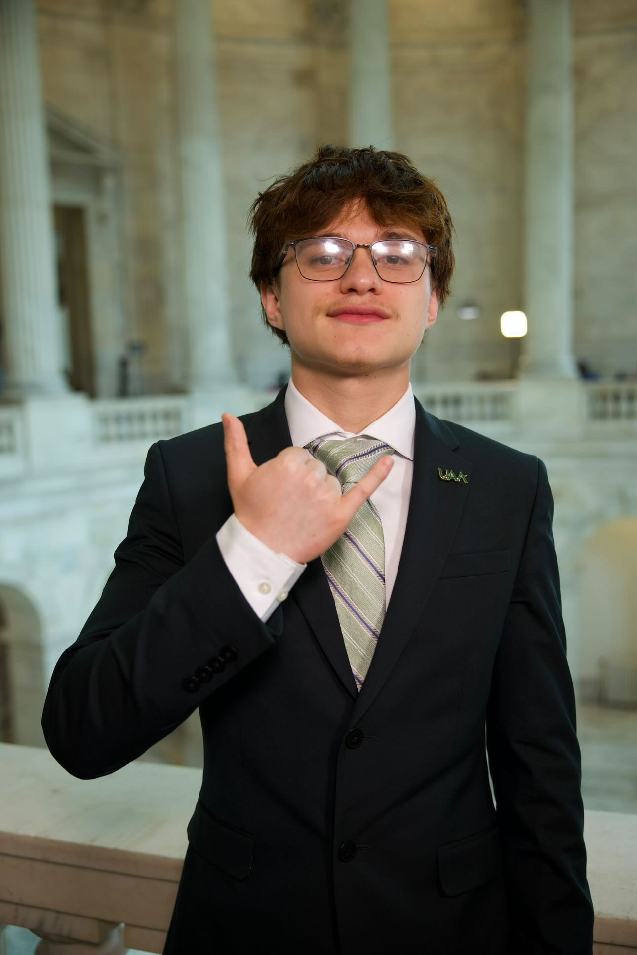 Man in suit throwing the shaka hand gesture