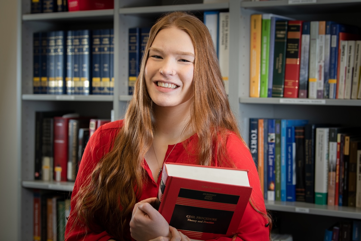 Legal studies student holding a textbook.