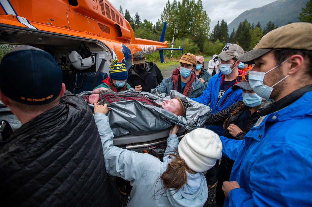 wwami students loading a man on a stretcher into a helicopter