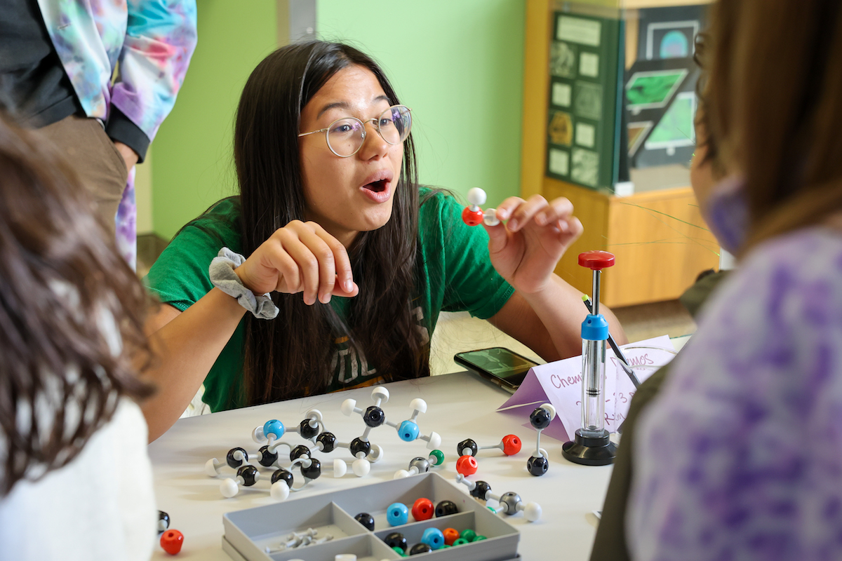 A CAS student demonstrates molecular models