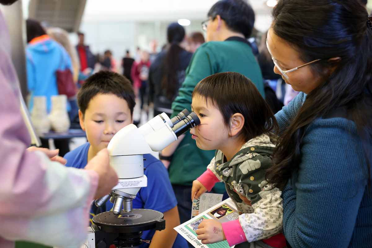 little girl looking into a microscope