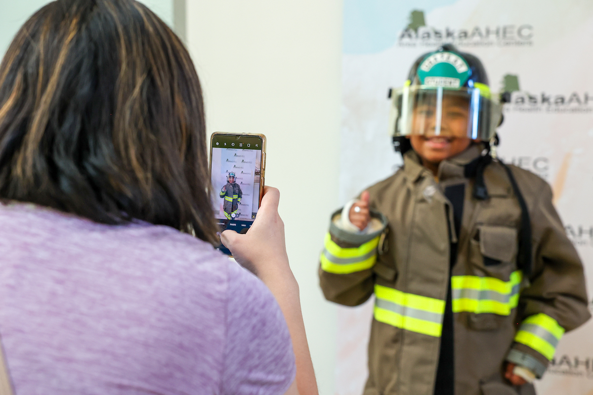 parent taking a photo of child dressed up as a fire fighter