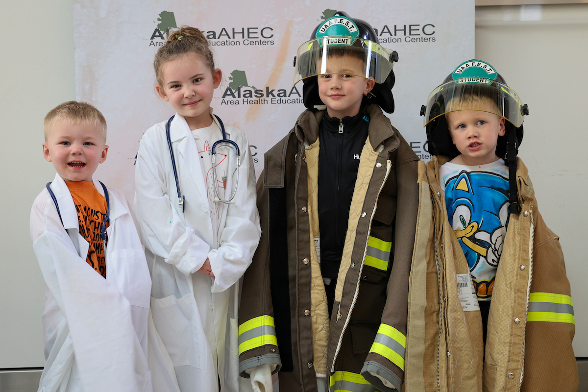 4 kids dressed up as doctors and fire fighters