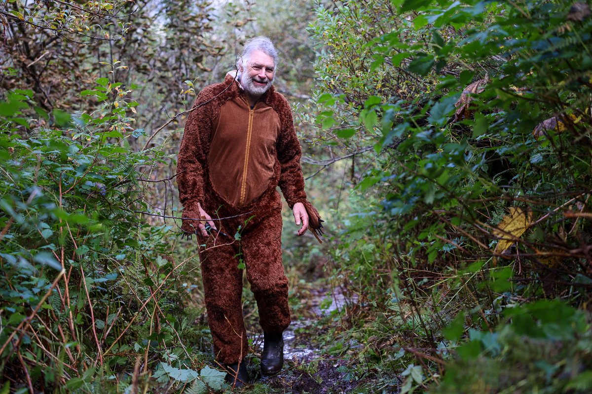 a man in a bear costume in the woods