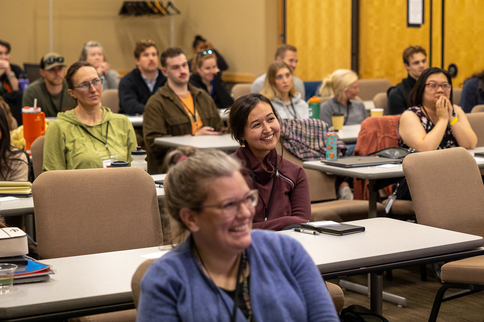 Seated students listening and smiling