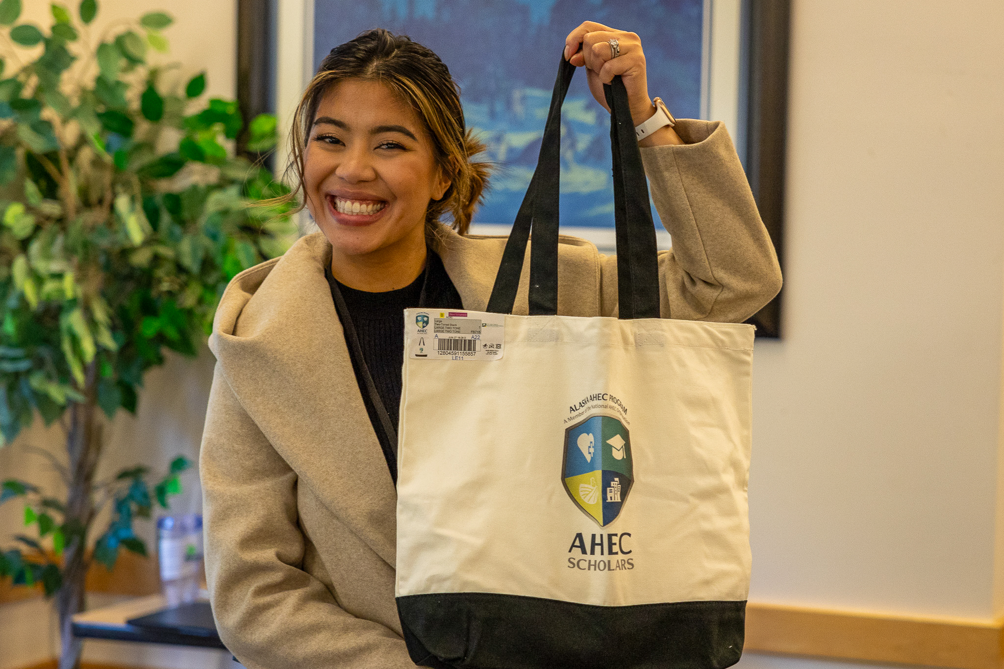 A woman holding up an AHEC swag bag