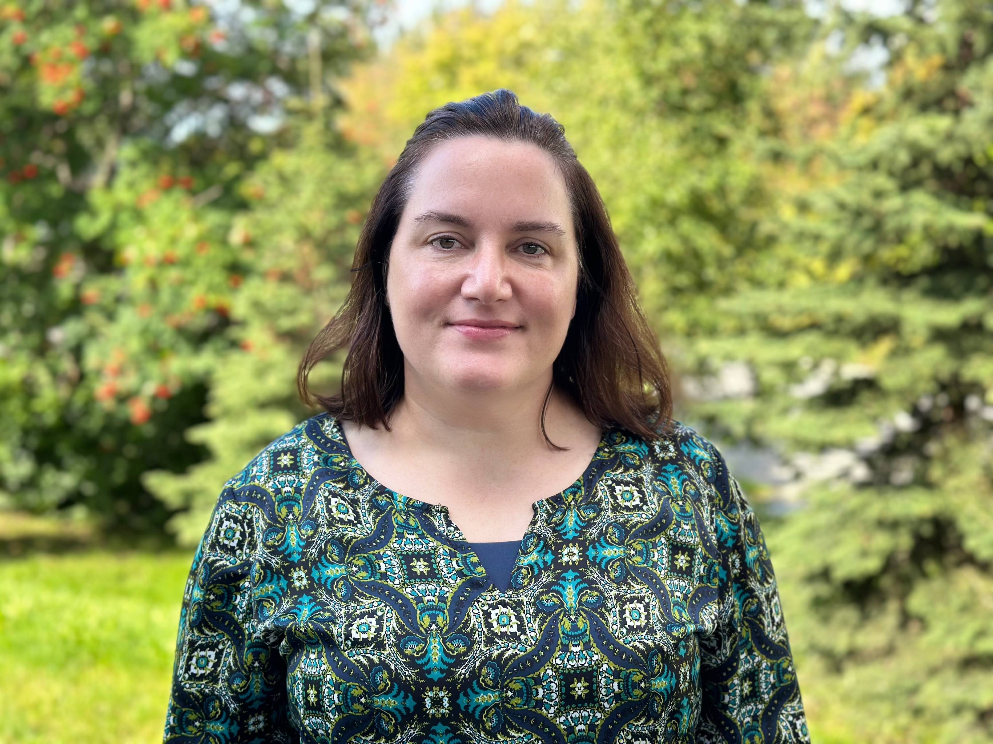 Sara Hannon stands outside smiling and facing the camera. 