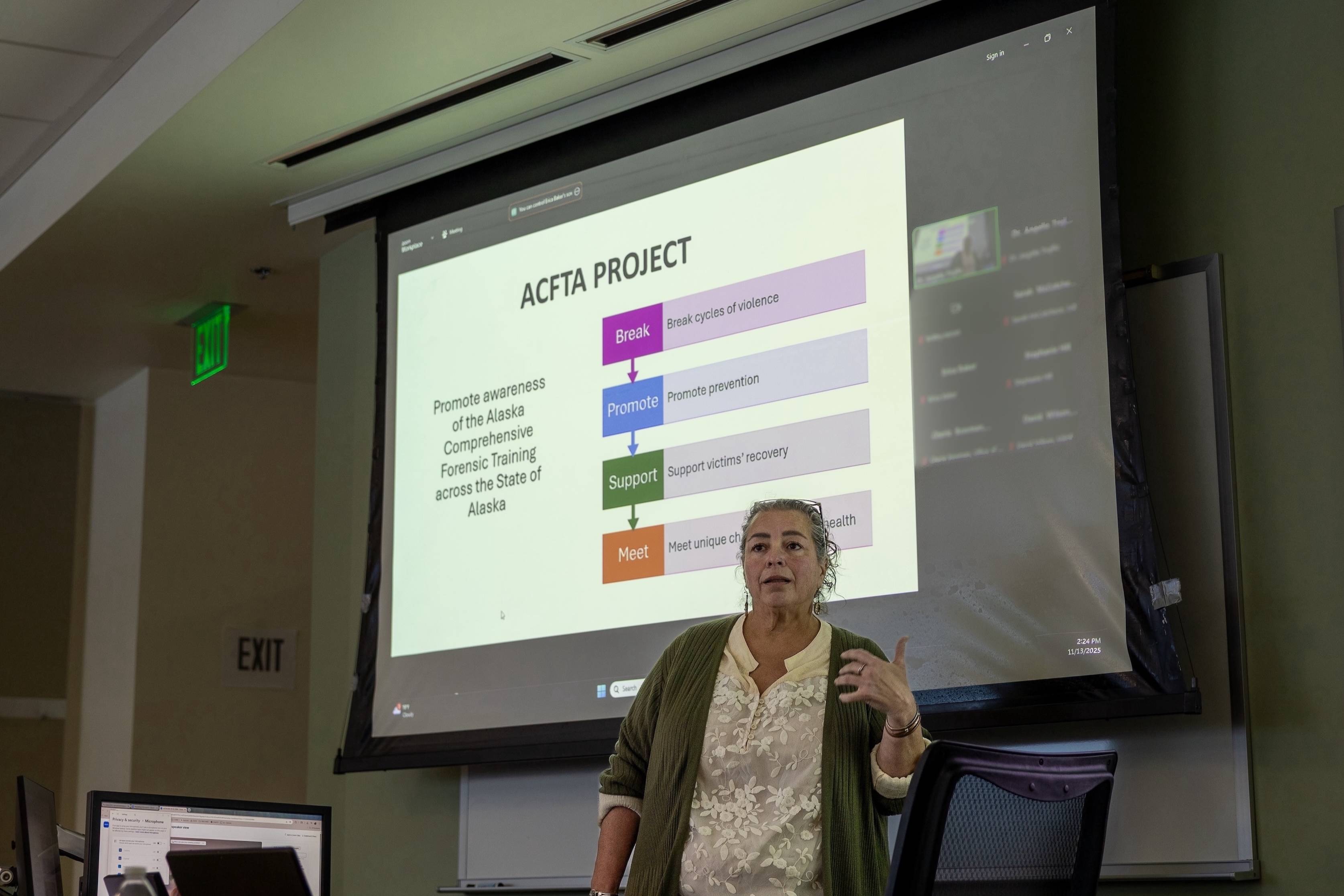 Dr. Angelia Trujillo stands in front of a projector screen that reads "ACFTA Project." She is speaking and gesturing with her hands.