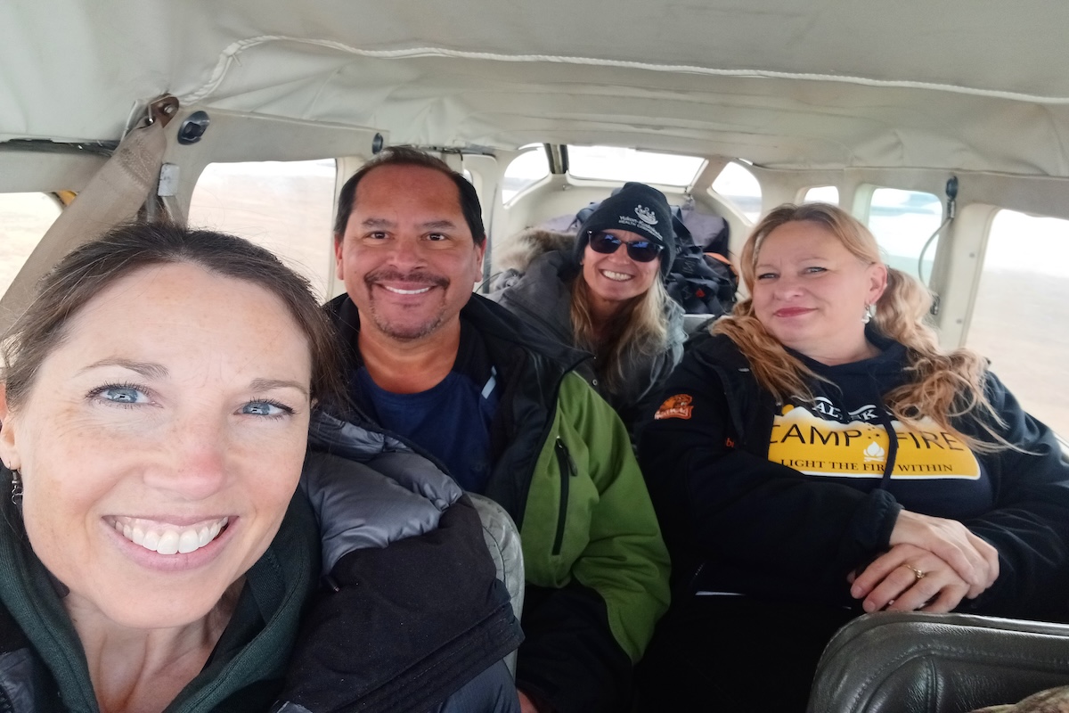 Four people smiling on a small plane