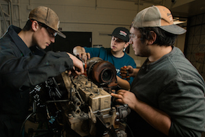 student working on a car engine