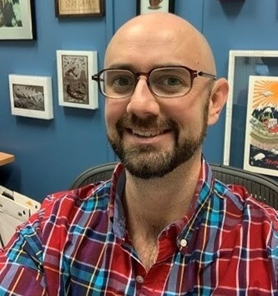 A headshot of Cameron Nay in his office