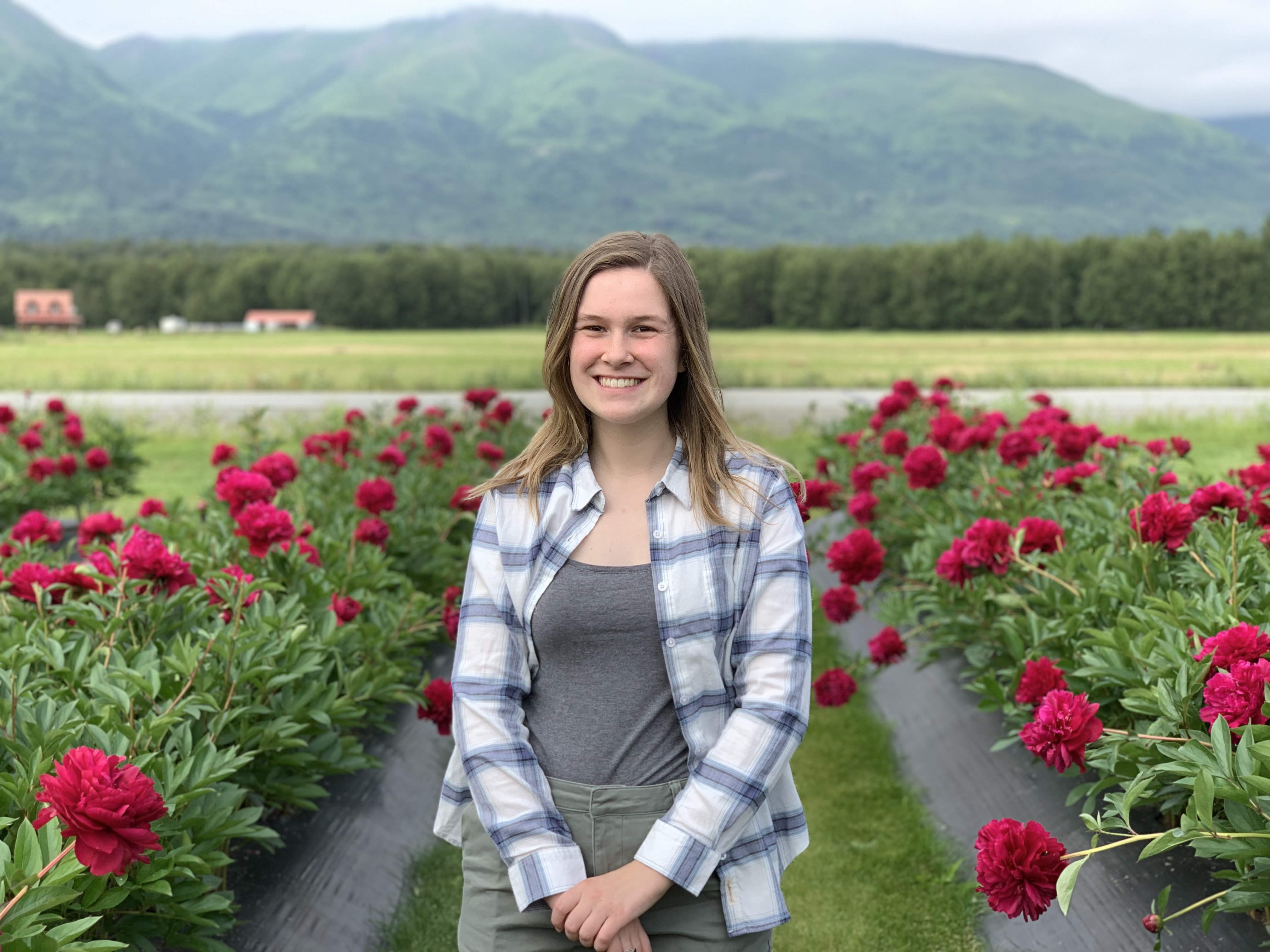 Keely Livingstong standing in front of rows of flowers