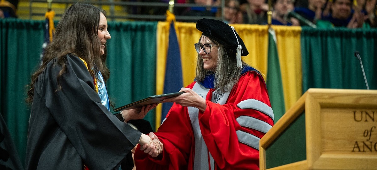 Commencement student speaker Albiona receives her degree from Honors Dean Dr. Ray Ball