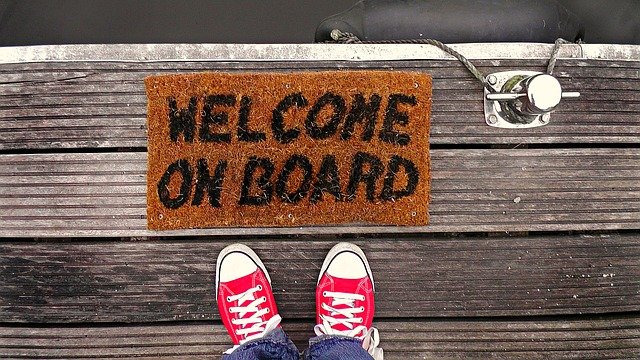 Welcome matt on a dock that says, "Welcome Onboard."