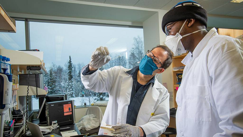 student and professor in lab coats