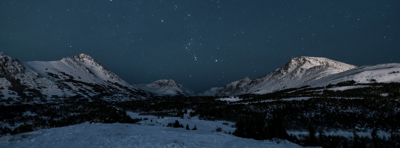 Snowcapped mountains under a starry sky