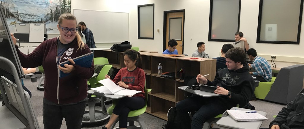 Staff member tutoring students in the Learning Commons