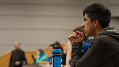A student listens intently in a lecture hall