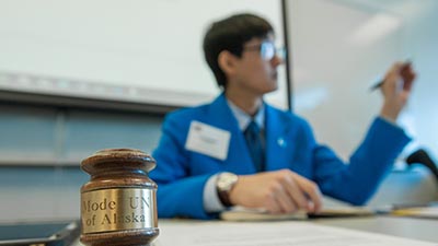 A student talks with a Model UN gavel in from of him