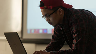 A student in class working with a laptop