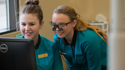 Two dental students looking at results on a computer