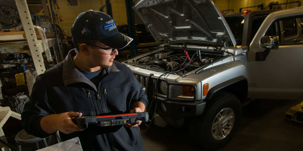 An automotive student using diagnostic equipment
