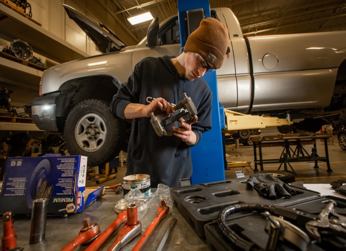 An automotive student working on brakes