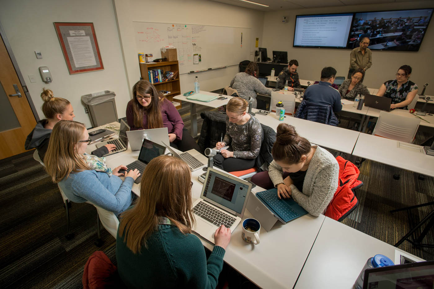 Students working together on laptops in a lecture