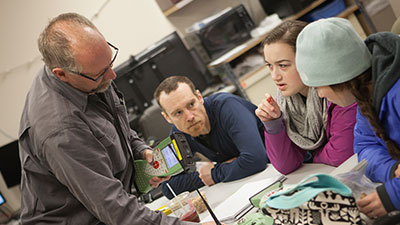 Three students talking to an instructor
