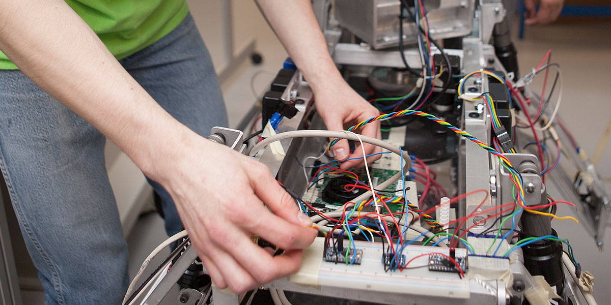 A student working on the wiring of a machine