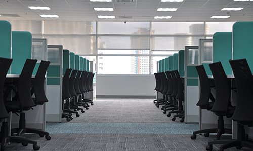 Office room with cubicles and rolling office chairs