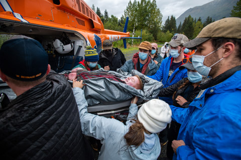 Students practice loading a simulated patient into a helicopter