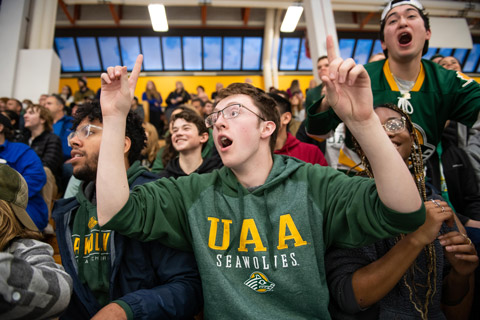 Benjamin Brown and other students watch Seawolf Hockey
