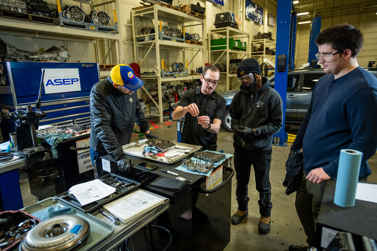 A professor teaches three students about automatic transmission