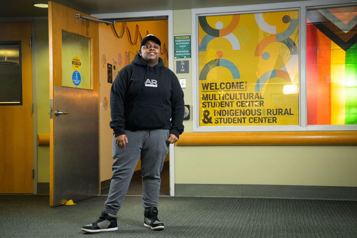 Woman in black hoodie poses in front of office