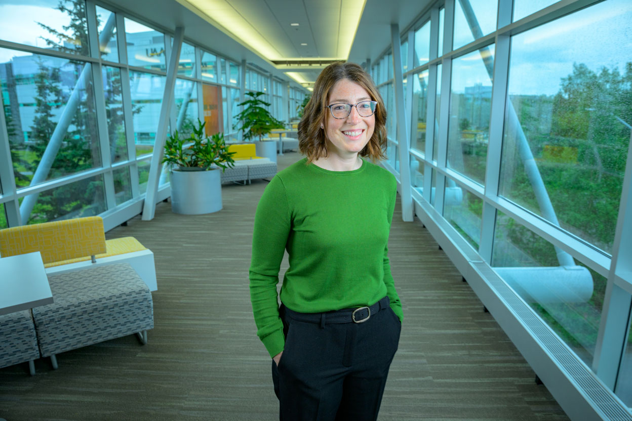 Woman wearing glasses and green sweater smiling