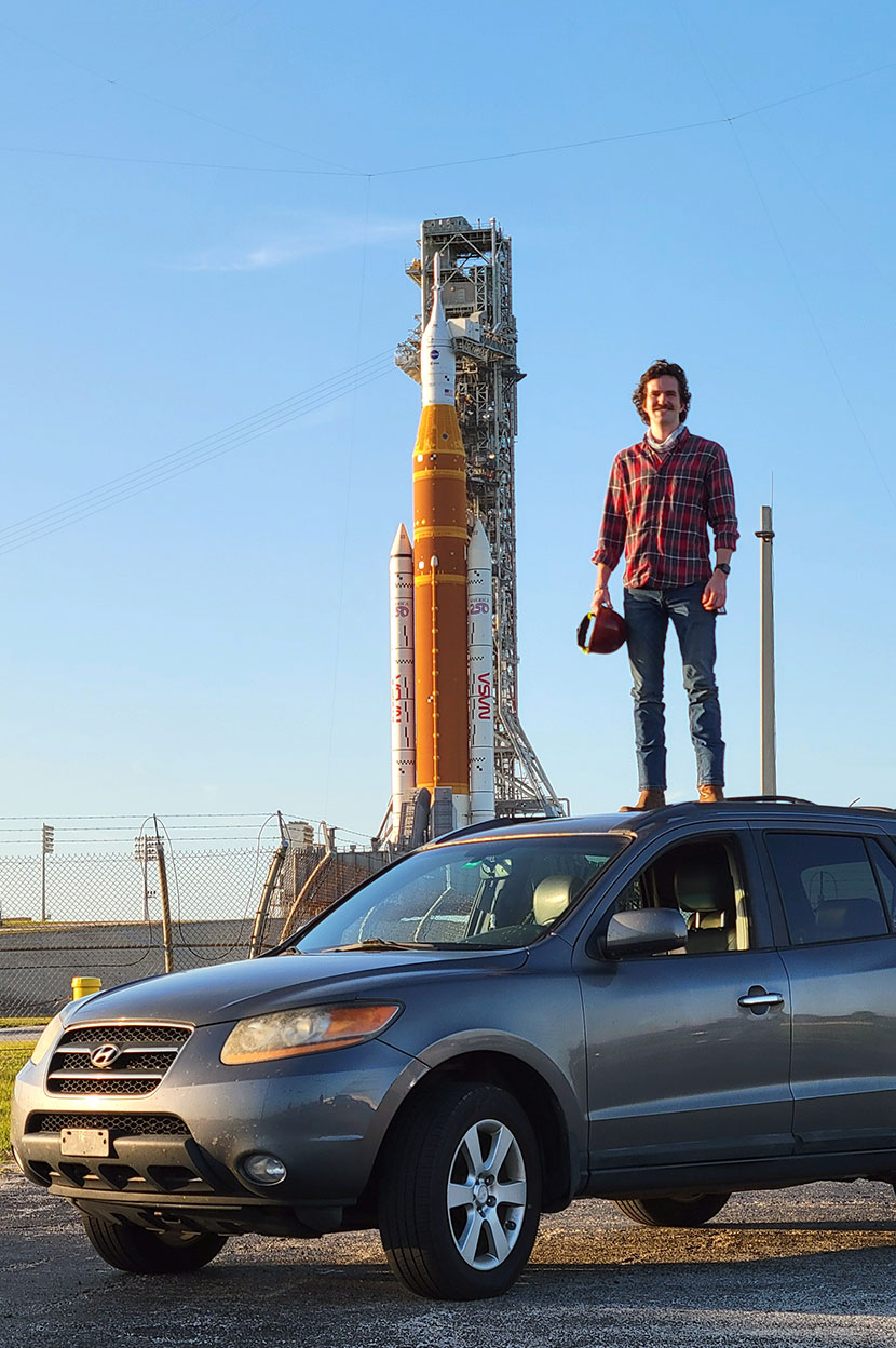 Man standing in truck bed with rocket in background