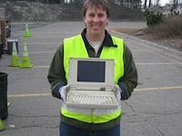 Bynum Jackson, assistant sustainability director, holds a laptop so old that it had a floppy disc 