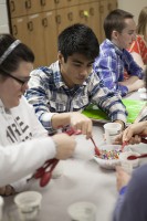 Students at Steller Secondary School scoop beads during an economics game UAA professor Jim Murphy devised and helped them play.