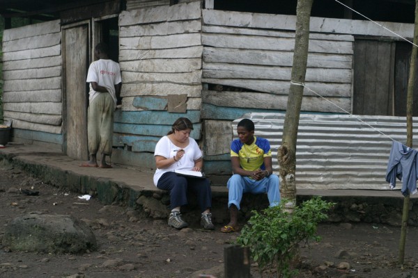 Health Sciences graduate student Patsy Peschel talks to Desmond, resident of Rhema Grace Orphanage, on the 2011 trip.