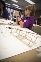 Ashley Smith sits near a balsa bridge she helped build. Photo by Theodore Kincaid/UAA