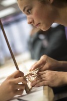 Hannah Romberg, 14, works on a balsa bridge at a UAA summer engineering academy. Photo by Theodore Kincaid/UAA