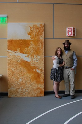 Jenna Brooks and Bryan Box stand by Box's "Into the Abyss" artwork, which he displayed in the Sept. 11 "Service Before Self" art auction. The piece is still available for display, he says. (Photo courtesy of Bryan Box)