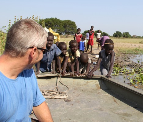 Jason Hahn, program director for the Alaska Sudan Medical Project, looks at children playing with a boat in Old Fangak, South Sudan. (Photo courtesy of ASMP) 