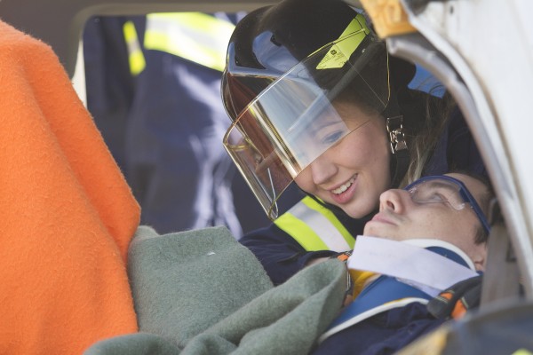 An EMS student reaches her classmate, posing as a crash victim (Photo by Philip Hall/University of Alaska Anchorage). 