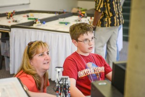 Lisa Turner watches as her son, Josh, shows her software he used to program a robot during a UAA summer engineering robotics academy session. (Photo by Tracy Kalytiak/UAA)