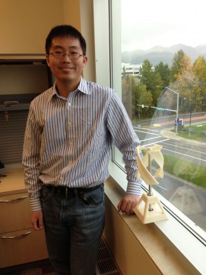 Jifeng Peng, an engineering professor at UAA, is working with a colleague at Stanford and residents of Igiugig to use vertical axis wind turbines to generate cheaper energy for the rural community. The model on his windowsill illustrates one example of a vertical axis wind turbine. (Photo by Kathleen McCoy/UAA)