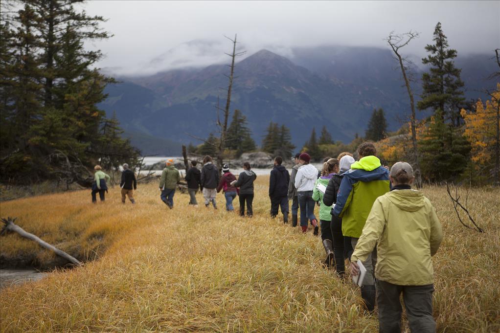 Dr. Kristine Crossen (at left, in green) leads her students through a marsh near Bird Point during her Anchorage Field Studies class this fall (Photo by Philip Hall / University of Alaska Anchorage). 
